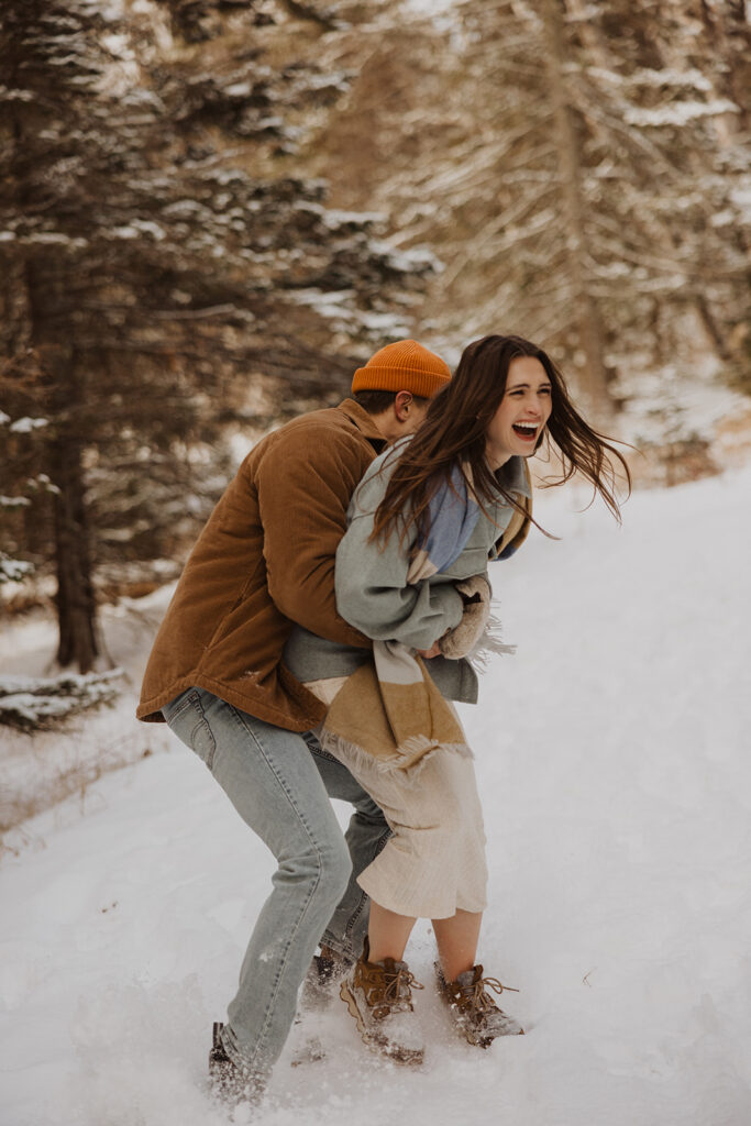 Engaged couple plays in the snow on Black Beach North Shore, Minnesota