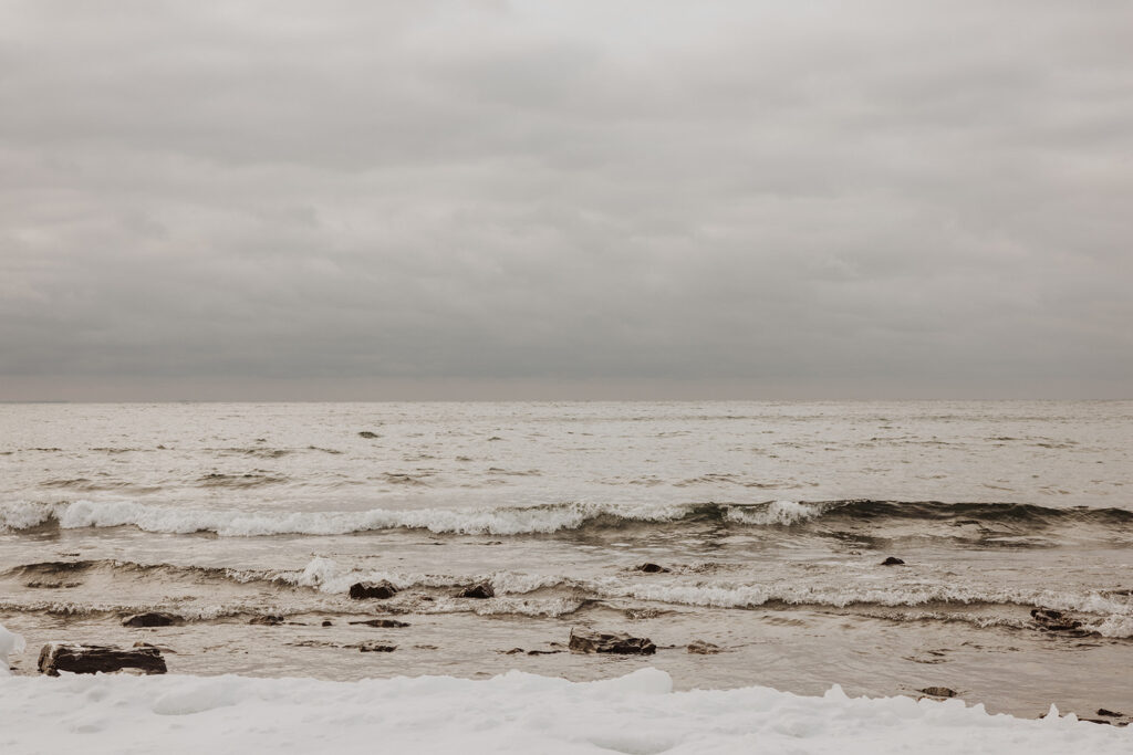 Waters of the North Shore lap on the shoreline of Black Beach