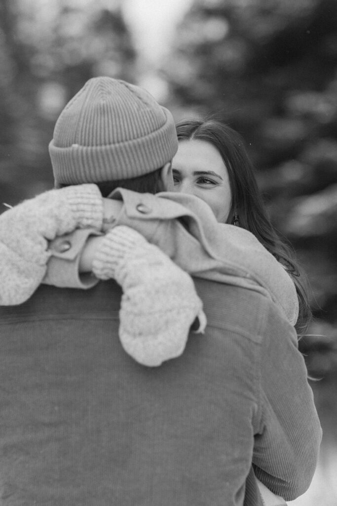 Woman wraps her mitten-clad hands around fiance's neck in North Shore engagement