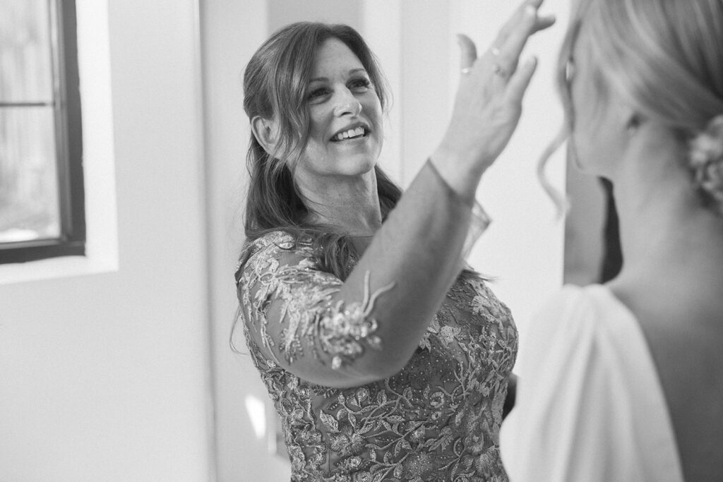 Mother of the bride gently fixes bride's hair