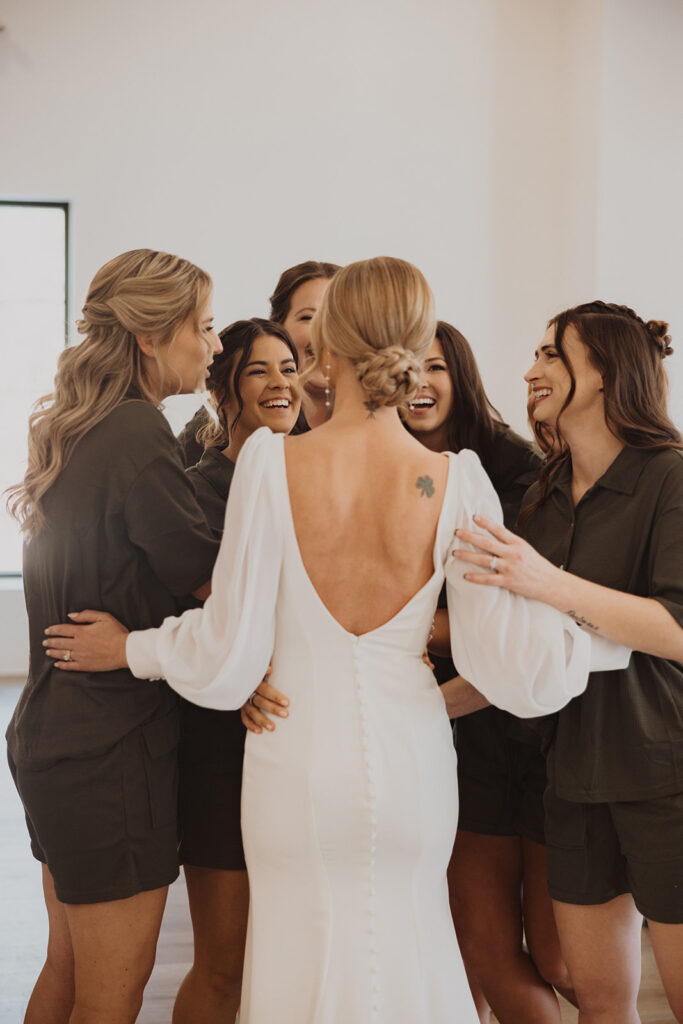 Bride and her bridesmaids hug