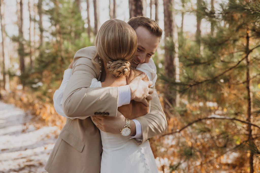 Groom hugs bride during excited first look at winter wedding in Minnesota