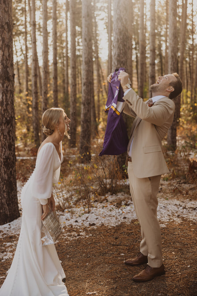 Groom throws his head back in laughter at wedding gift from his wife