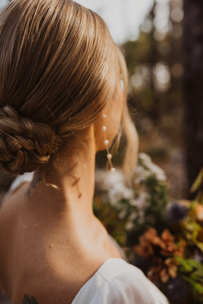 Winter bride stands in the sunlit glow at Pinewood Weddings and Events in Minnesota