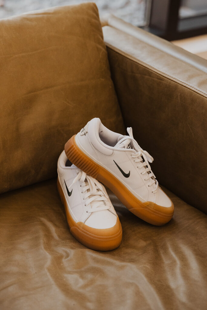 Nike shoes sit on leather couch at winter wedding venue