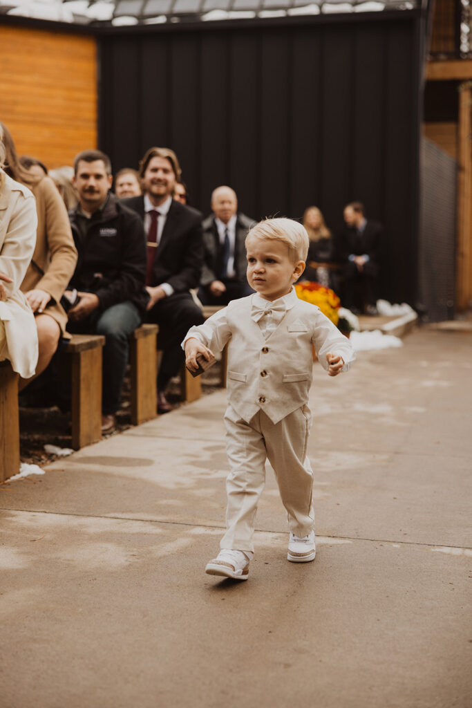 Ring bearer walks down the aisle at Pinewood Weddings and Events in Minnesota