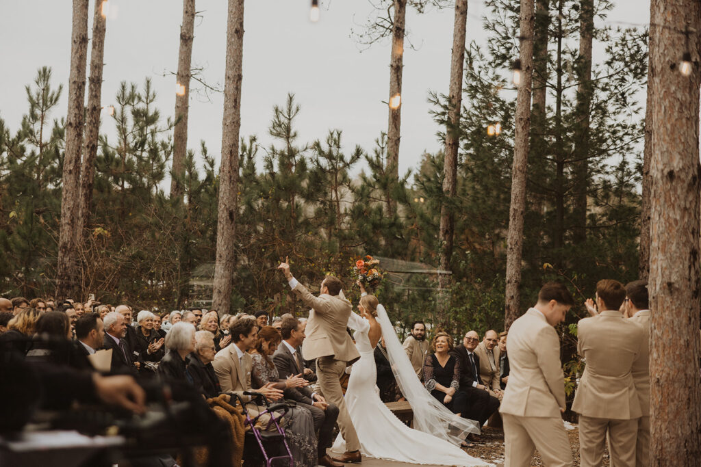 Bride and groom celebrate becoming husband and wife among all of their family and friends at Pinewood Weddings and Events