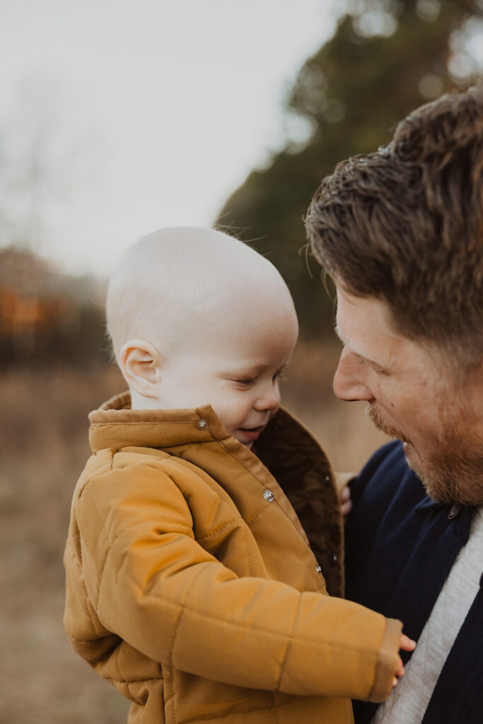 Baby plays with dad's shirt as he talks to him