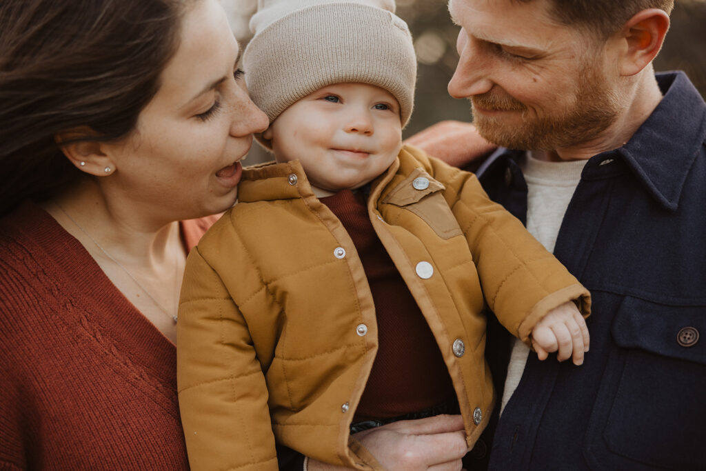 Baby smiles between his parents