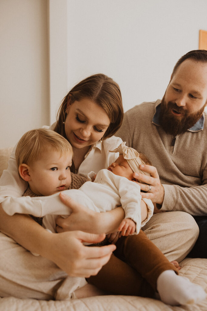 Parents talk to young son as he tries to decide what he thinks about newborn baby