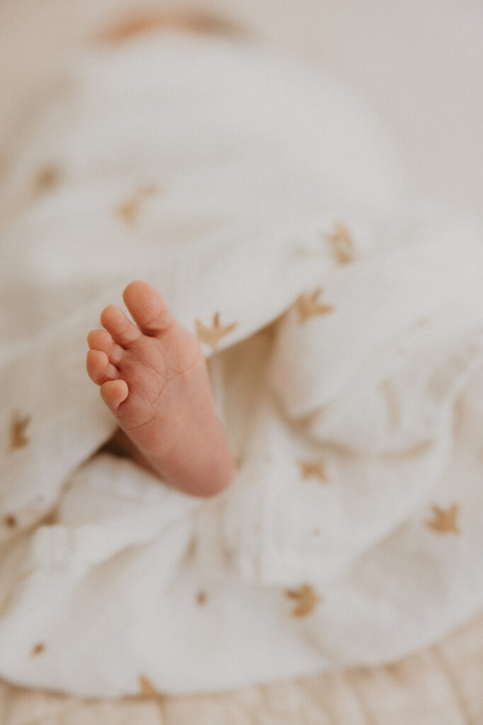 Newborn baby toes wrapped in soft muslin blanket