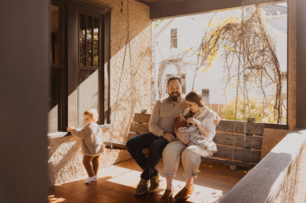 Young family sits on the porch of their new home in Minnesota