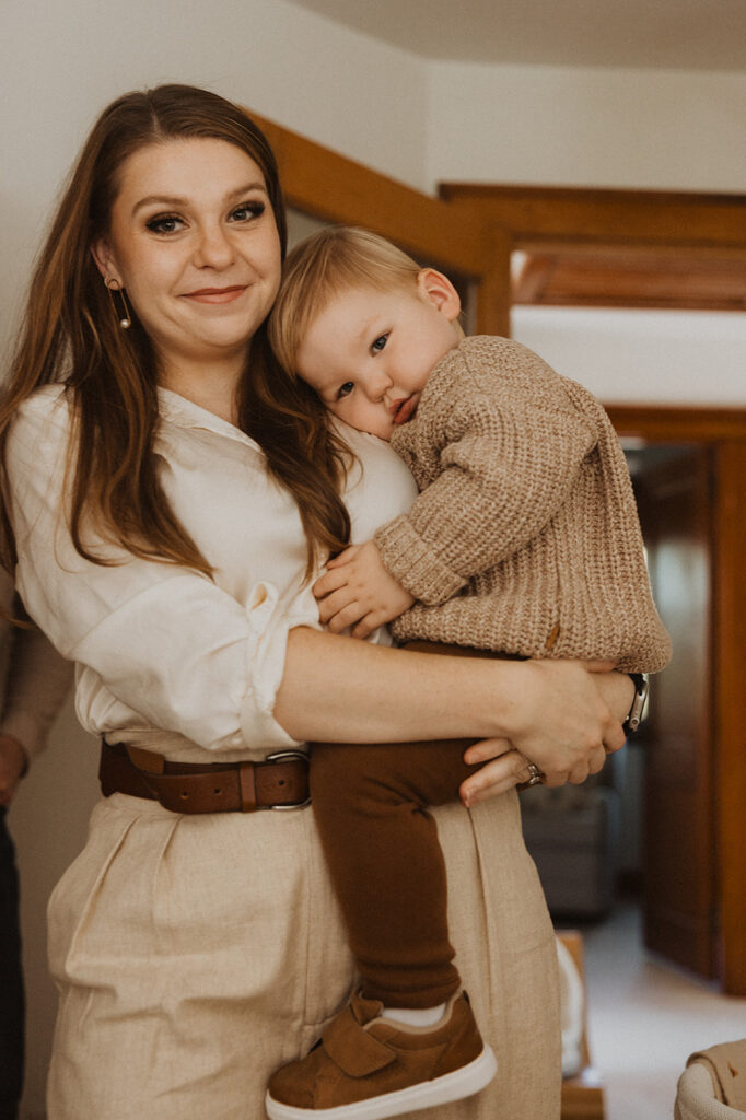 Young boy rests his head gently on his mom's shoulder